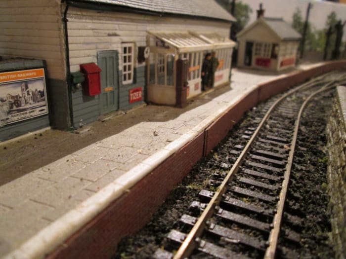 The view along the platform to the Ratio signal cabin (minus lamp room and steps). Platform is Wills' Victoria Stone, track is Peco Setrack and Streamline - travel poster from Trackside Signs