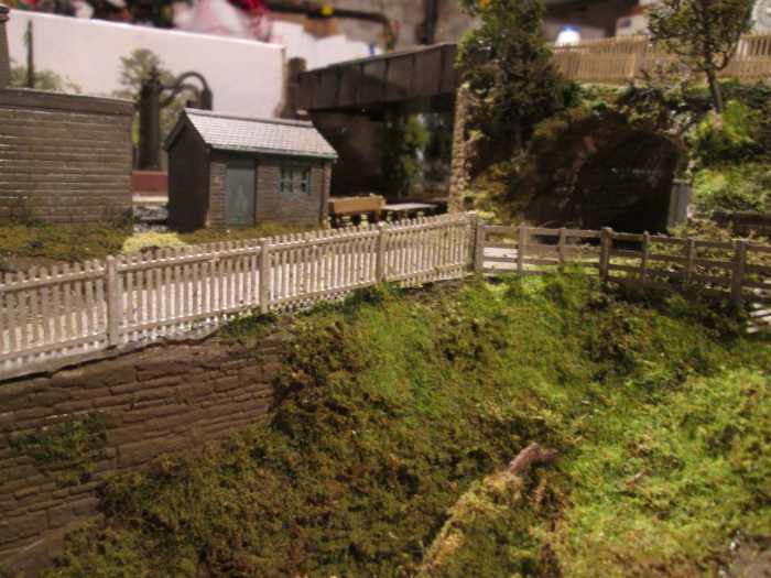 Part of the 'carr' (marsh) beside the coal depot inclined road; two modified plastic yard building kits make up the scene. Coarse stone wall below the road is Wills', of course.