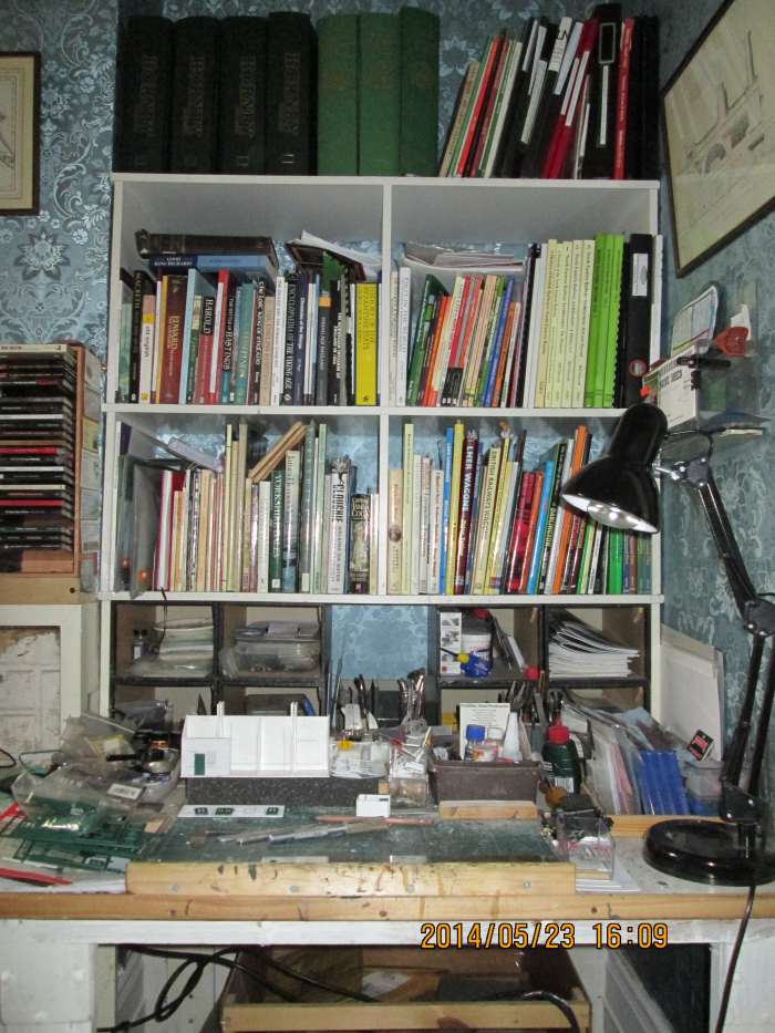 The work area. Reference 'Library' above (bound magazines, paperbacks, preservation info, NYMR and WR share certificates). Other books below, tools & materials, cutting board etc