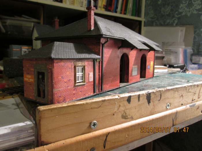 The goods shed looking along from the office to the loading doors (sliding doors) seen on the work table - card kit modified with moulded plastic section, etched brass and white metal parts kits, and white metal figures (see Thorpe Carr page)
