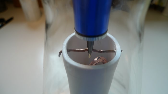 How the improved condenser is connected to the sample container. The subtle way how the copper wire is bended makes sure it locks itself up. We can now slide it away for a better access to the container.