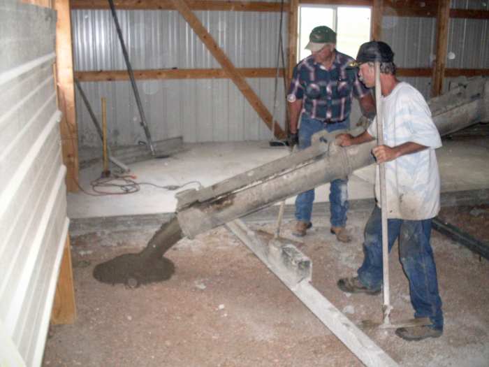 The concrete pour is started in the back of the building. My husband helps direct the flow of the concrete, keeping it well within the appropriate section.