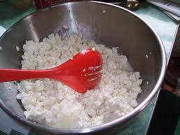 Sprinkle the salt and blue-mold powder blend over the curds and mix them together with a slotted spoon or your hands