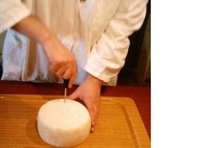 Remove the cheese from its mold and run a sterile ice pick through the cheese from one flat side to the other
