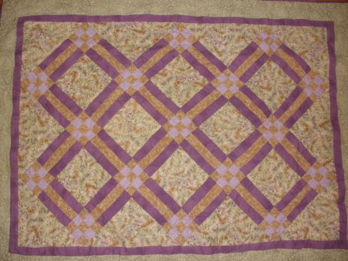 This traditional quilt uses rail fence blocks and nine patch blocks in a diagonal setting.