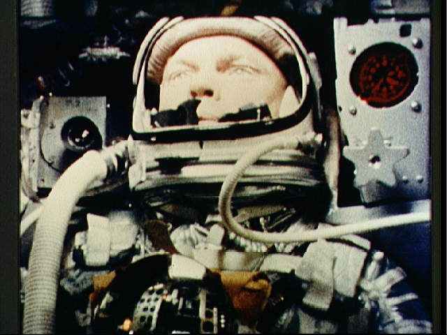 Photo of John Glenn taken during Friendship 7 mission shows hoses attached to either side of the helmet, one for venting carbon dioxide, and one to help seal the faceplate when closed. Photo courtesy of NASA.