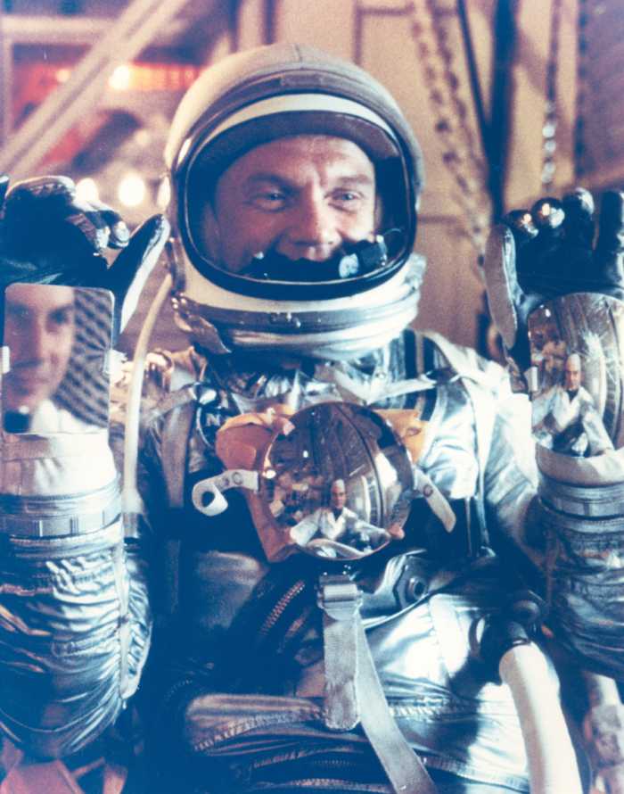 John Glenn shows the mirrors that aid with control panel visibility - one on each wrist, and one on his chest. Photo courtesy of NASA.
