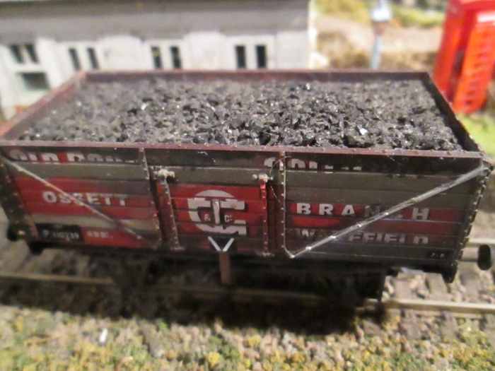 A Dapol private owner wagon, weathered and several planks scraped clean of the original paintwork (to resemble replaced planks) with Modelmaster wagon number transfers The 'v' on the side indicates bottom doors for unloading into coal drop cells