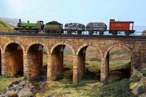 The viaduct - a module added to the layout - with a very short pick-up goods going over. Vintage NER locomotive and rolling stock. Note the 'Birdcage' Brake