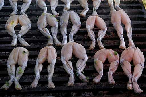 Seasoned Frog Legs Being Grilled before Eating.