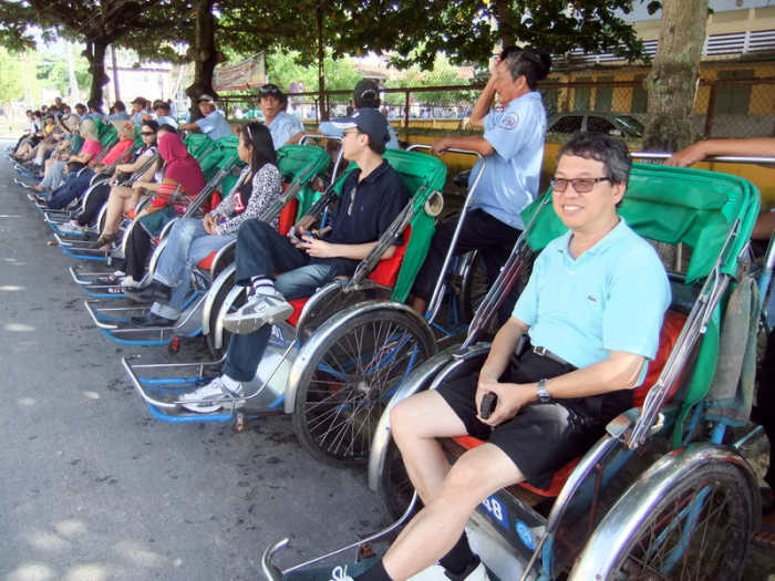 Street Photo in Hoi An, Vietnam: Our office had 65 cyclos to take us around Hoi An, giving business opportunities to these drivers