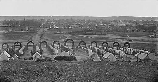 A well-ordered Regimental camp in garrison by a small town. Note the very elaborate entranceways to each Company Street. The larger tents in the foreground are for the officers of the Regiment
