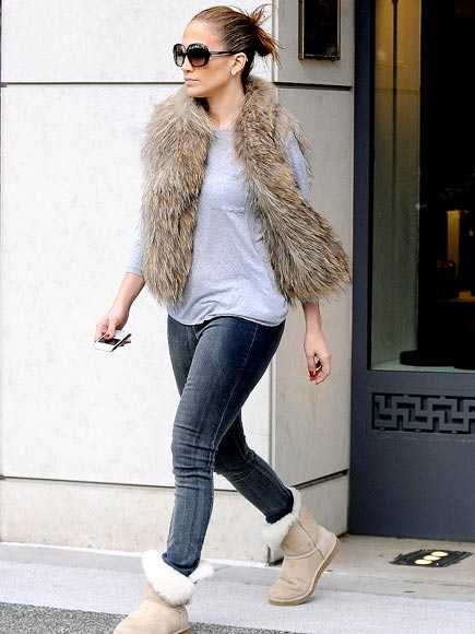 Stylish Jennifer Lopez gracefully pulls together the fur vest with blue jeans and a t shirt and Uggs
