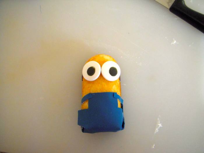 Place a small amount of icing onto backs of eyes. Place eyes on Twinkie, over headband. Congratulations! You have a Minion.