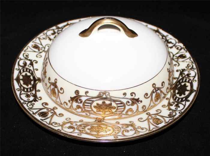 Here is a round covered butter dish from Noritake in the 175 pattern, also called the Wedding pattern, Christmas Balls, or “Ornaments”. The pattern features a white background with cream band and raised gold flowers and scrolls. It was produced from