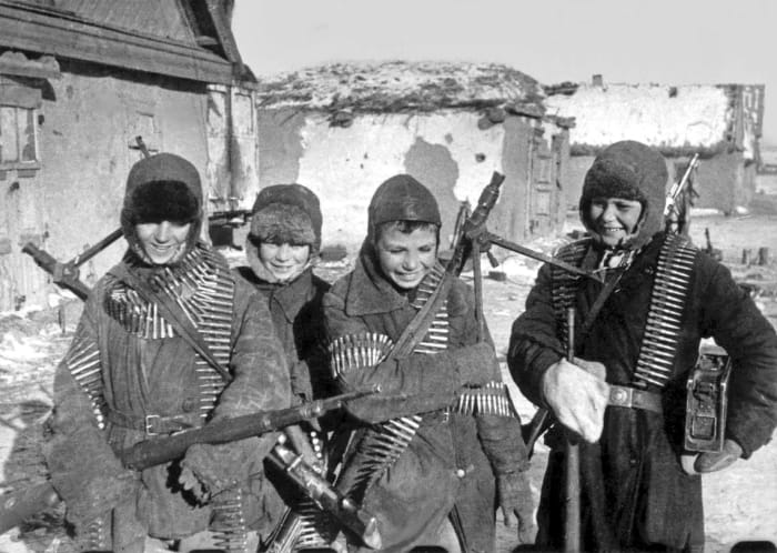 Soviet children with recently abandoned German weapons after the battle ended at Stalingrad.