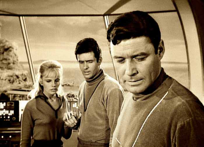 Judy Robinson, Major Don West and Professor John Robinson working on a problem in the Jupiter 2 their home and spacecraft.