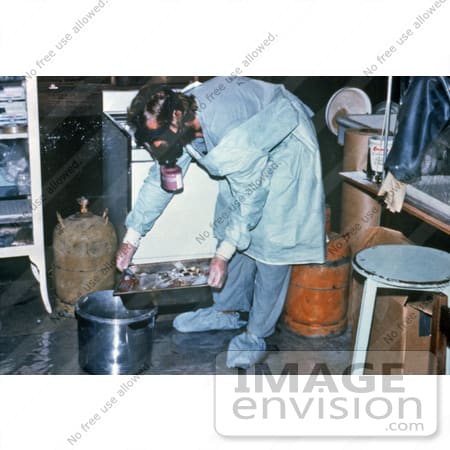 Stock photography of a heavily protected technician is shown discarding blood specimens collected during the Ebola outbreak in Zaire, 1976. Researchers hurried to identify the cause of this epidemic, pinpoint its source, and halt its spread. The dise