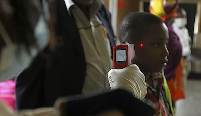 A boy's temperature is taken using an infrared digital laser thermometer at the Nnamdi Azikiwe International Airport in Abuja.