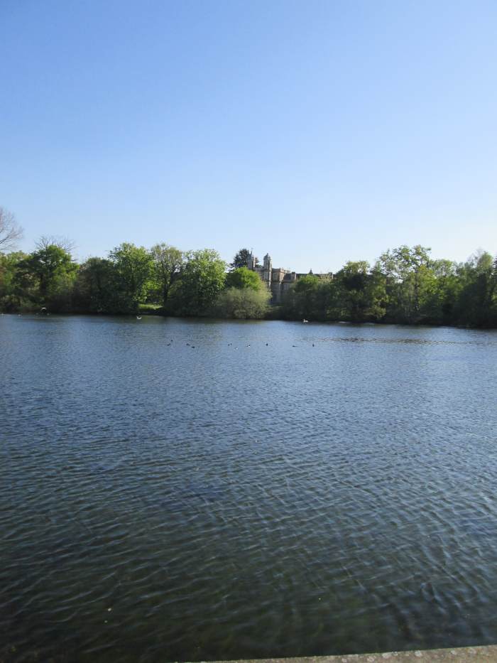Across the Eagle Pond from the roadside is the Tudor-esque front of Snaresbrook Crown Court in its arboreal setting
