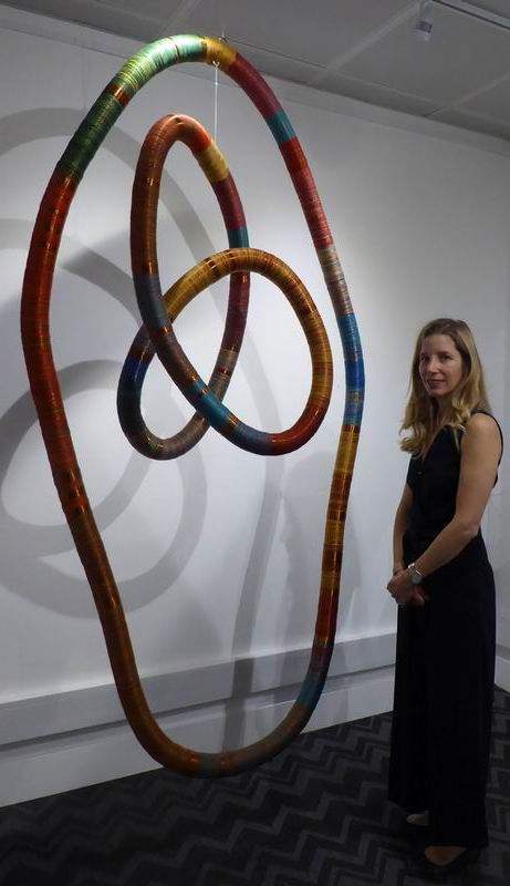 Curator Claudia Trosso stands beside Inka Space, a mobile structure made with copper and thread.