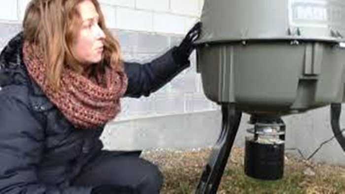 Sara Dubois, chief scientific officer with BC SPCA shows the feeding unit placed at the VCC-Clark SkyTrain station.