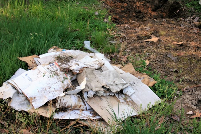 Clip the grass close and cover it with cardboard or plastic. When the vegetation beneath dies, remove the covering.