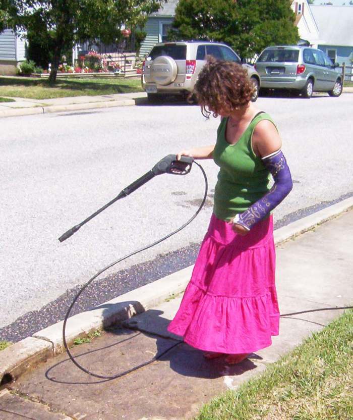 If a young lady with a broken arm can power wash the sidewalk, so can you. More powerful pressure washers need to be handled with both hands.