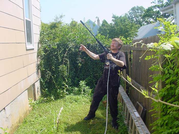 Power washing the house : Dave would have better control of the power washer if he used both hands.