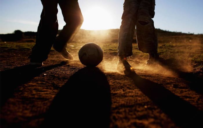 Children play soccer in a field in Erasmia Township in South Africa. Children are still playing, without boots, grass and and proper soccer clothing, despite the success of the World Cup Tournament in south Africa