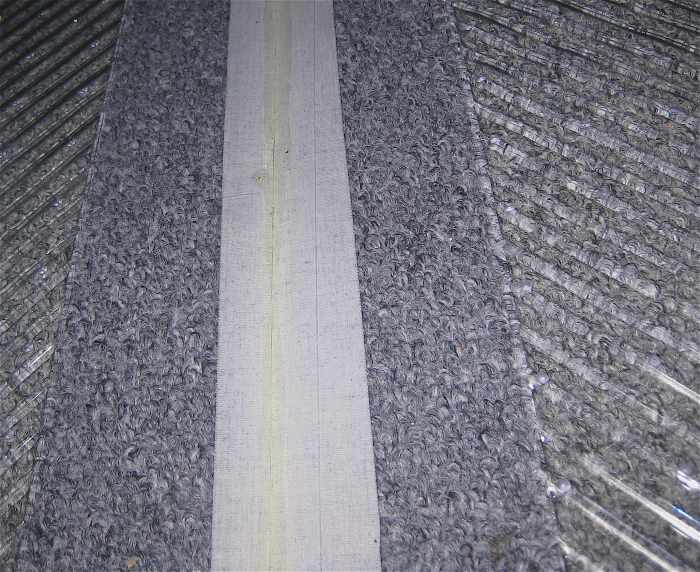 close-up of sticky side of gaffing tape and carpet seen through the heavy duty clear plastic floor mat