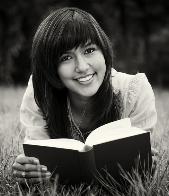 A woman models 'book reading'. She can get away with not reading this book because she has a modeling career. You, on the other hand, will actually have to read the book.