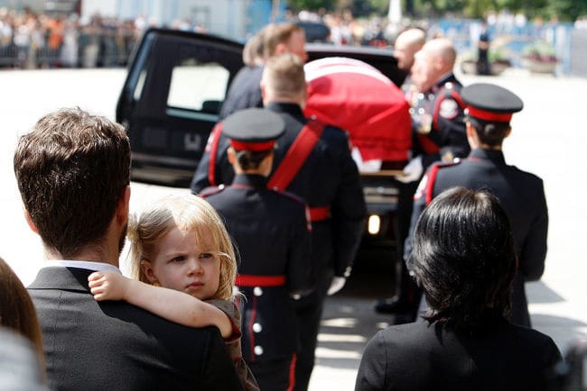 Sarah Layton's daughter Beatrice looks out as her granddad's casket is carried from city hall during the funeral for NDP Leader Jack Layton August 27, 2011.