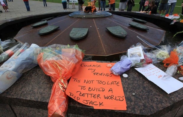Mourners left floral tributes and notes, including this one featuring the words of former NDP leader Tommy Douglas, at the Centennial Flame in Ottawa.