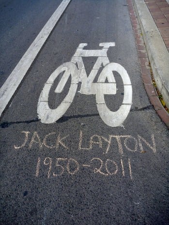 A tribute to Jack Layton written in chalk adorns a Toronto bike lane. As a member of city council, Layton promoted city cycling.