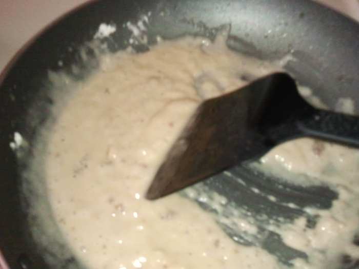 Add in your flour in small amounts stirring quickly with a spatula. When you get to this consistency, you are ready to add milk. Don't worry about lumps at this point, you'll get them out in the next step.
