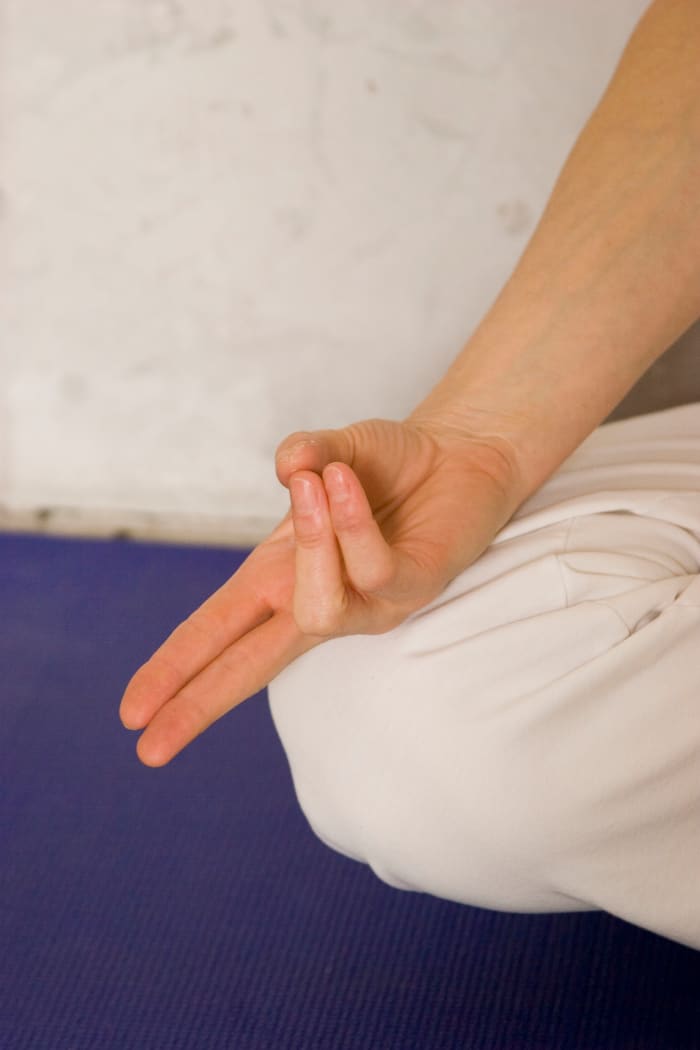 Form Vishnu Mudra with right hand for alternate nostril breathing (Anuloma Viloma). The breath is connected with life energy. By learning to regulate the breath, we purify and open natural channels for energy to move freely.