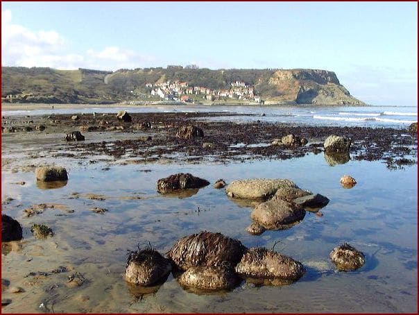 Runswick strand, the rocky foreshore - fishing vessels are launched at high tide and stored in a 'boat park' to the left of the landing in the view above