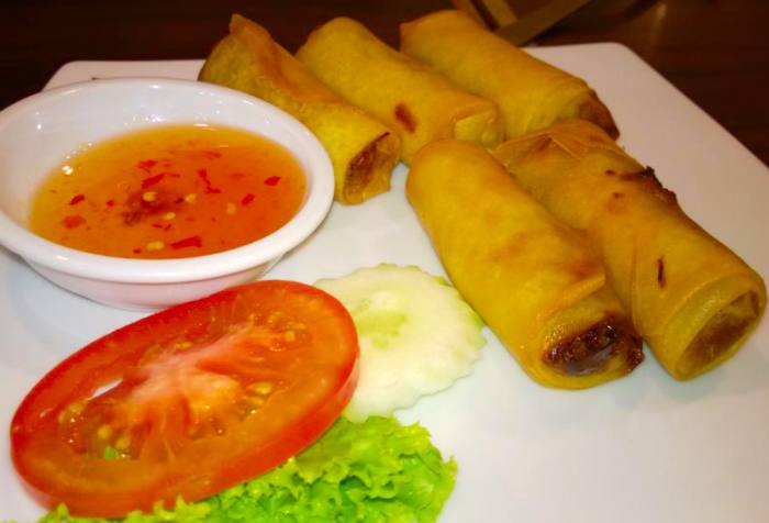 Deep-fried popiah is a crunchy and delicious snack. Chili sauce and garnish with tomato-cucumber and lettuce.