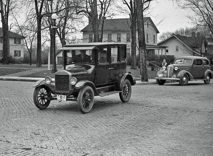 Early 1920s Model T Ford at center with 1936 Chevrolet at right
