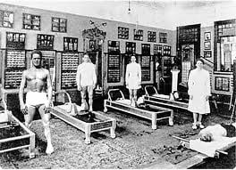 Pilates Studio with Four Men and Four Pilates Reformers in Black and White