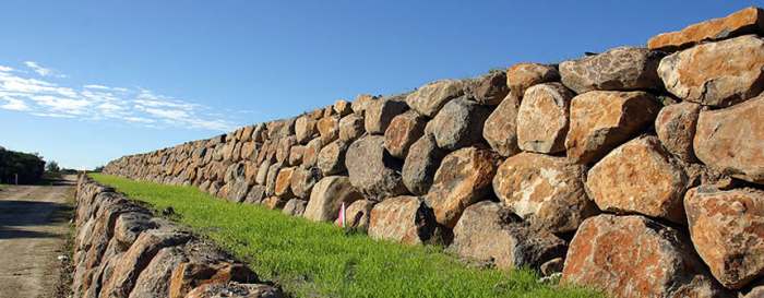Rock retaining walls blend well in the gardens, as they are natural since rocks are found everywhere in the natural state among trees and grass.