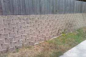 With this type of blocks you don't use mortar, you can just lay them dry; this type of wall is built leaning against the bank, all you have to do is to start the wall level, and when you lay next block on the top it will just sit a bit back by itself