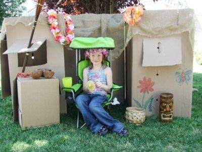 Enjoying a cool tropical drink -- pineapple and mango juice -- on the 'front porch' of a cardboard tiki-hut.