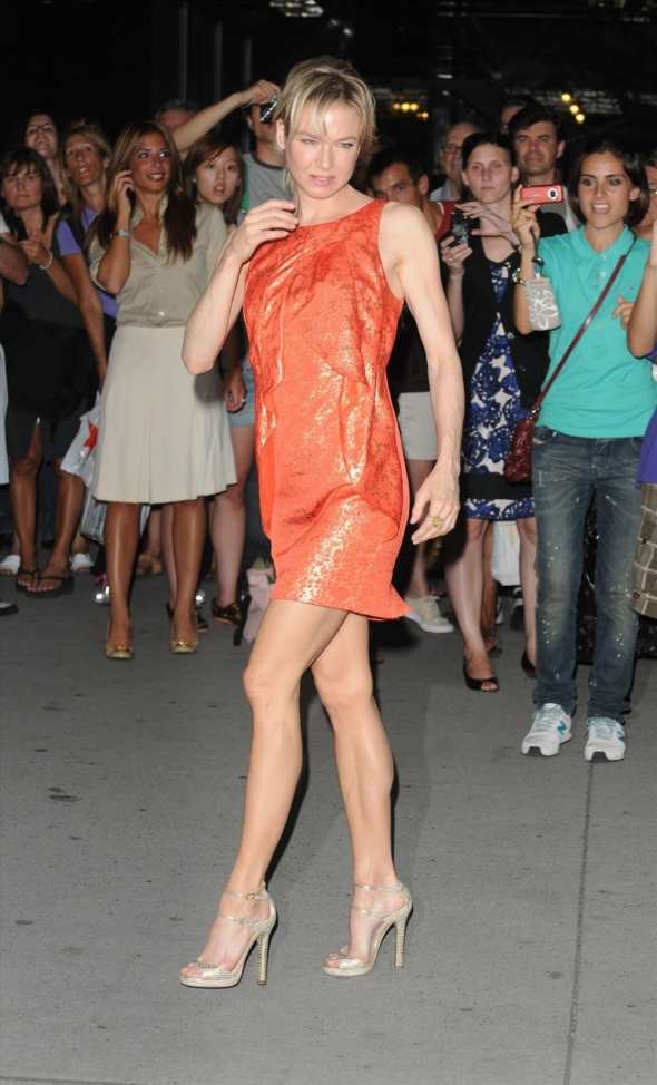 Renee Zellweger displays her hot legs in a short orange dress and high heels at the screening of The September Issue.