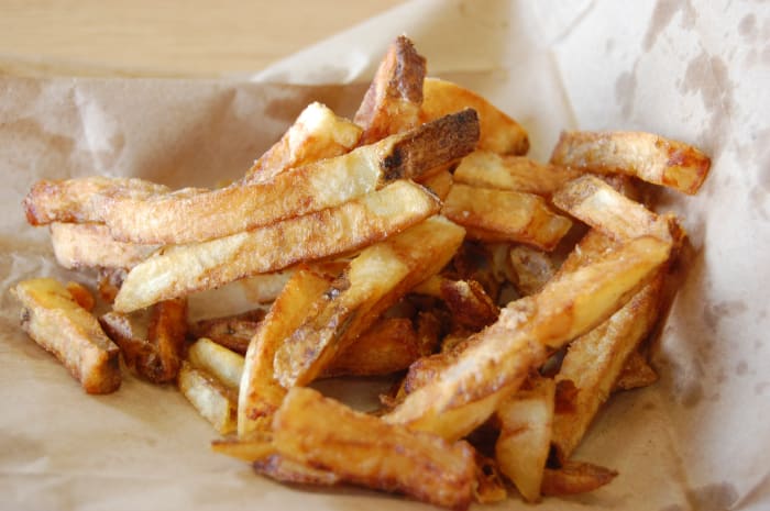 At Five Guys a regular order of fries has 620 calories and 30 grams of fat. That's the bad news, the good news is they are cooked in peanut oil and are very very tasty.