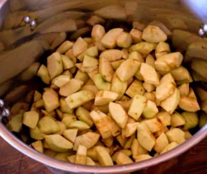 Slice apples into cooking pot. Cut any shape or style you desire, keeping in mind that smaller pieces will fall apart easier during the heat processing to come.