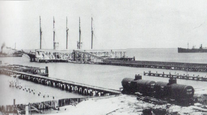 Boca Grande phosphate dock, Circa 1915, is a massive conveyor belt. The phosphate is unloaded at the railhead and carried by the belt to the ship. Note the ship being loaded is a five masted "Yankee Schooner," replaced by steamships by the 1920s.