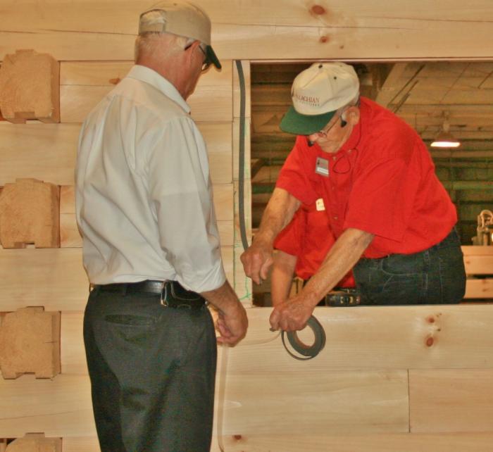 Appalachian Log Structures employees demonstrate the company's multiple techniques for sealing windows and doors.
