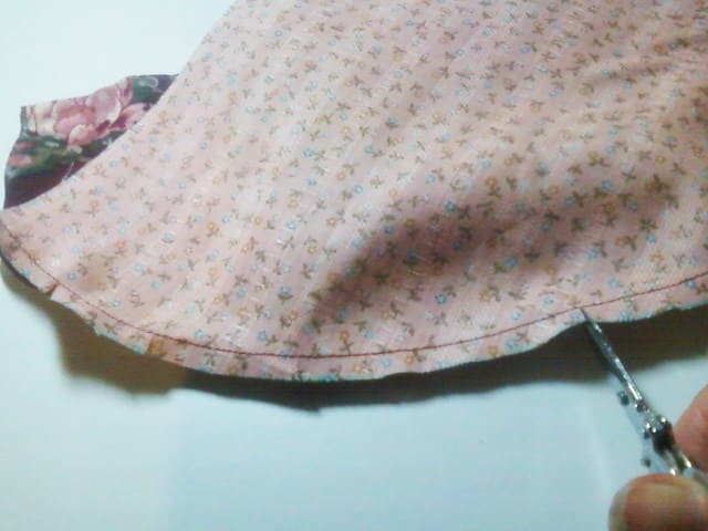 Once I've sewn the pieces together with a narrow, 1/4" seam, I trim the edges with embroidery scissors. BE CAREFUL NOT TO CUT THE SEAM'S STITCHES! The slits will help create ease so the curved hem will lie flat.